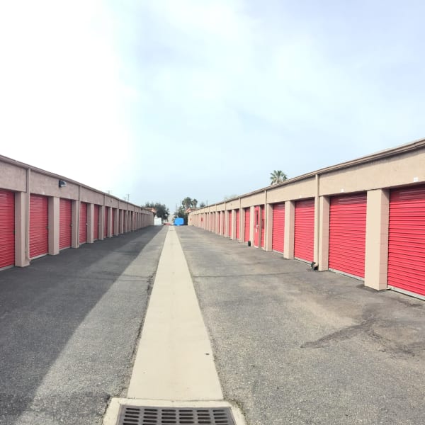 Outdoor storage units on either side of a wide driveway at StorQuest Express Self Service Storage in Mesa, Arizona