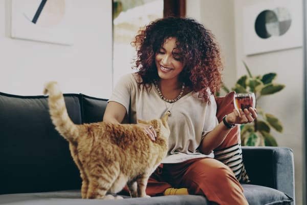 Woman sitting on her couch at her home with her cat at Liberty SKY in Salt Lake City, Utah