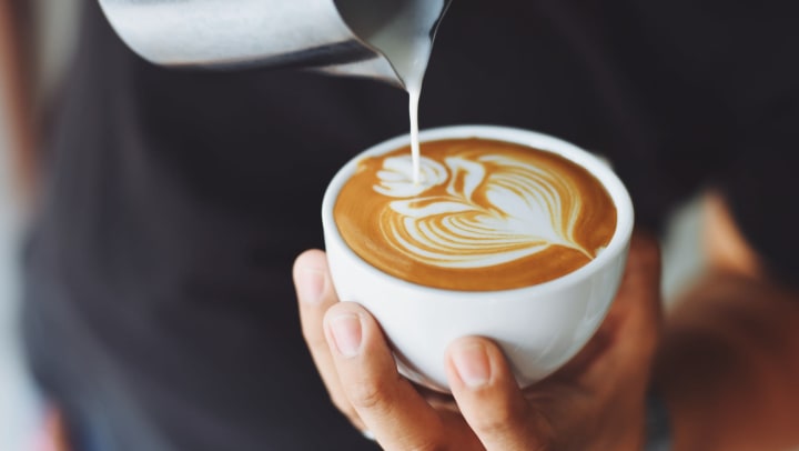 Barista pouring a cup of coffee near Lux on Main in Carrollton, Texas