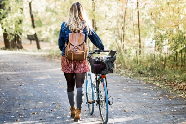 A woman walking her bike through a park near Commons at Briarwood Park in Brookhaven, Georgia