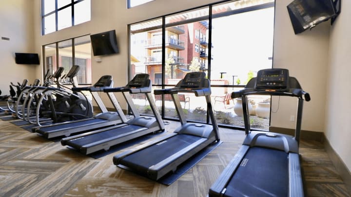 Stay active and energized at The Landing at Watermere Frisco's state-of-the-art fitness center. Featuring modern treadmills, elliptical machines, and expansive floor-to-ceiling windows, our fitness space offers a bright and inviting atmosphere with scenic views of the courtyard. Designed for wellness and convenience, residents can enjoy a comfortable workout environment with mounted TVs for entertainment and easy access to outdoor seating areas.