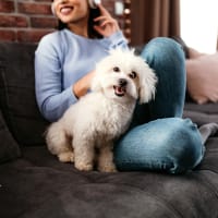 A woman sitting with her smiling dog at Riverstone in Macon, Georgia