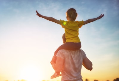 Resident dad with his daughter on his shoulders on a beautiful day outside their new home at 505 West Apartment Homes in Tempe, Arizona