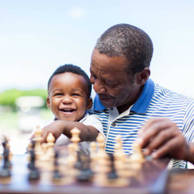 Resident playing chess with a baby at Landings of Minnetonka in Minnetonka, Minnesota