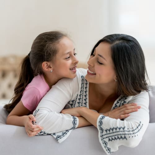 A happy mother with her daughter laying in the bed at Ramona Vista in Ramona, California