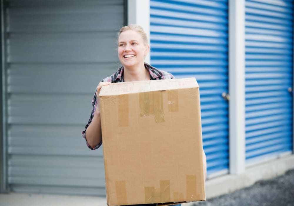 A woman carrying a box at an Everest Self Storage location
