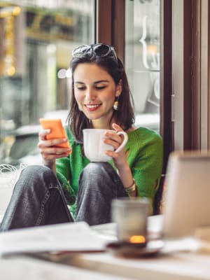 A woman checks her work email from a cafe near SoLa Apartments in Los Angeles, California