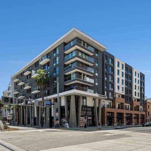 A building situated on the corner of a street, adding charm to the urban landscape at Aster, Long Beach, California