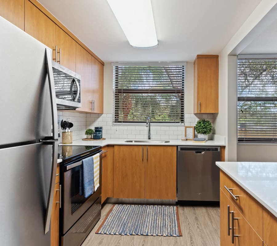 Fully-equipped kitchen with wood-style flooring at Bull Run Apartments in Miami Lakes, Florida