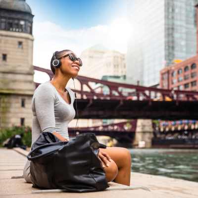 Resident listening to music near the water by Exhibit On Superior in Chicago, Illinois