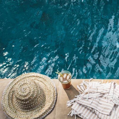 A sun hat and drink by the pool at Mosby Poinsett in Greenville, South Carolina