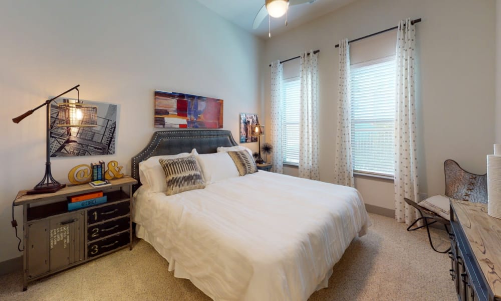 Bedroom with carpet and two large windows for lots of light at Bellrock Upper North in Haltom City, Texas