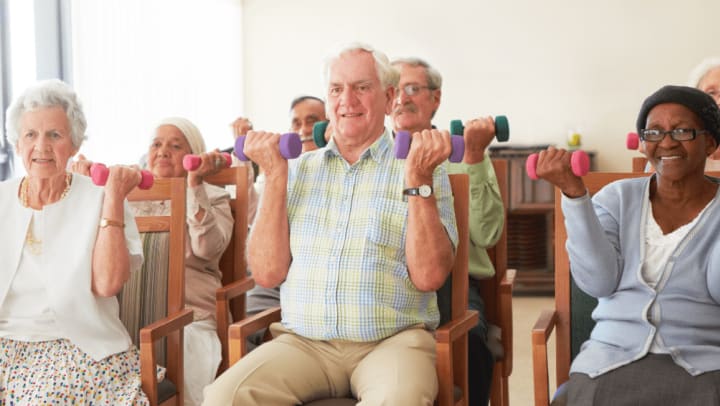 group of elderly adults doing arms exercises