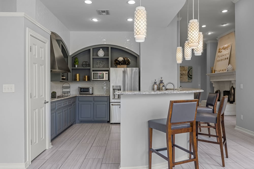 Community clubhouse kitchen and dining area with large windows at Marquis at Stonegate in Fort Worth, Texas