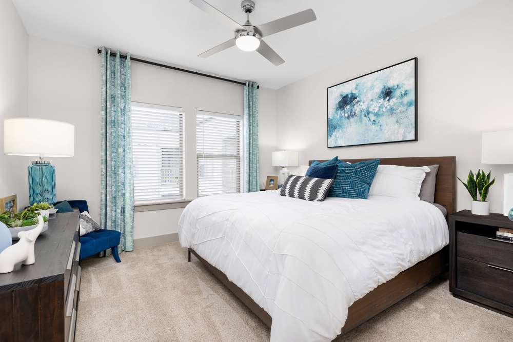 Spacious apartment bedroom with large bed and multiple art prints on the wall at SoBA Apartments in Jacksonville, Florida