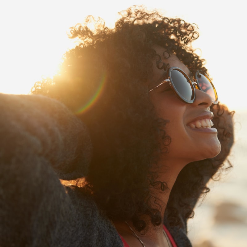 Resident greeting the sun from her seaside balcony outside a live/work unit at Portside Ventura Harbor in Ventura, California