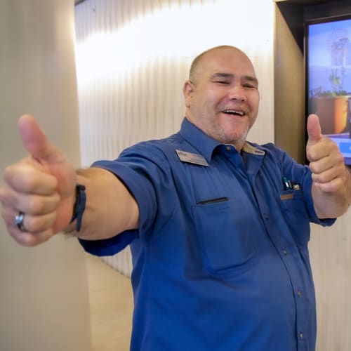 An employee holding up both thumbs at Pillar Properties in Seattle, Washington