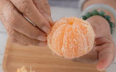 Resident peeling a fresh orange at Mattison Crossing at Manalapan Avenue in Freehold, New Jersey