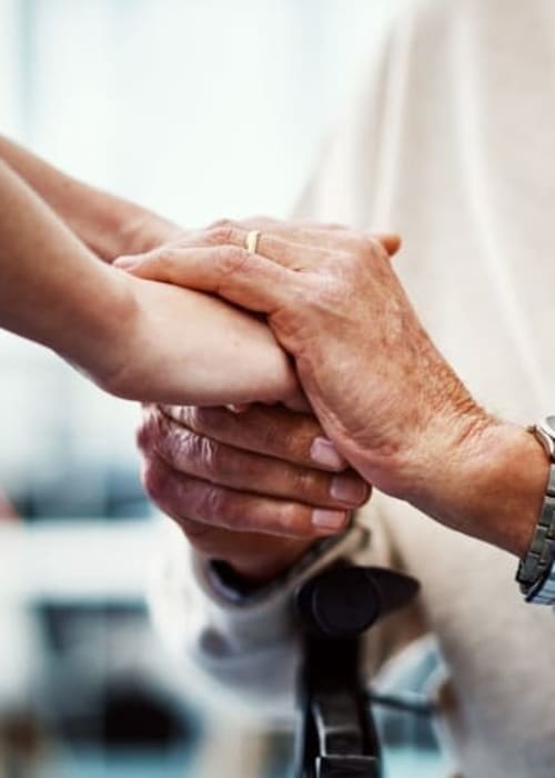 Staff member holding a resident's hands at Grand Villa of New Port Richey in New Port Richey, Florida