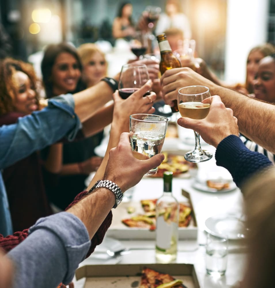 Group of resident friends out for a meal at their favorite restaurant and raising a toast to the good life at 2900 on First Apartments in Seattle, Washington