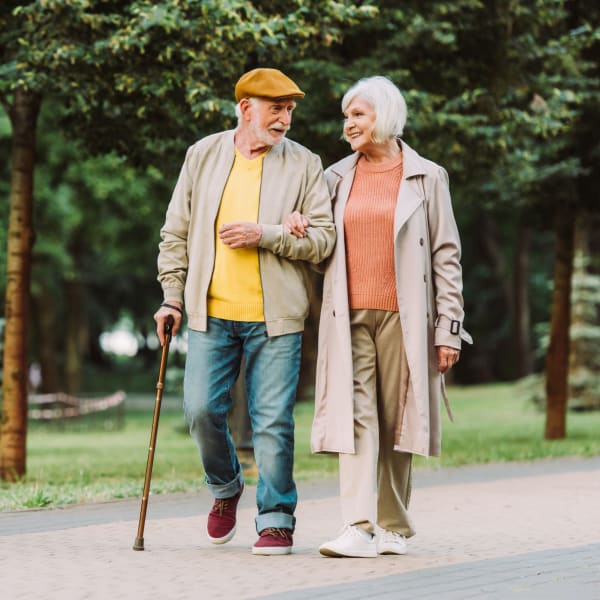 Two residents walking outdoors at Pacifica Senior Living Forest Trace in Lauderhill, Florida