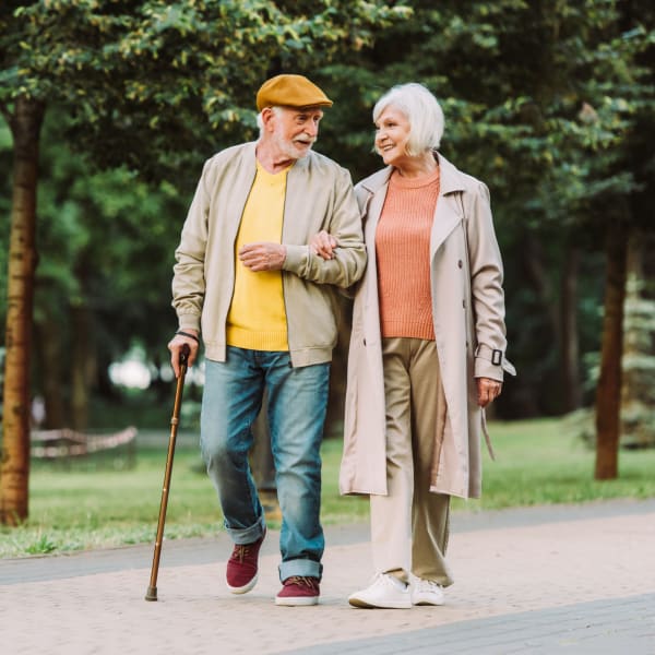 Two residents walking outdoors at Pacifica Senior Living Woodmont in Tallahassee, Florida