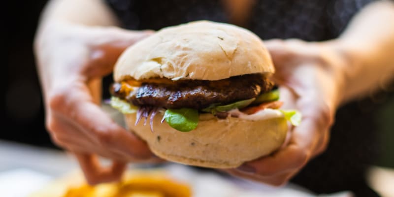 A resident holding a burger at a restaurant near Santo Terrace in San Diego, California