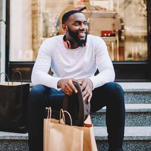 Man sitting on a bench with shopping bags near The Pointe at Warner Center in Woodland Hills, California